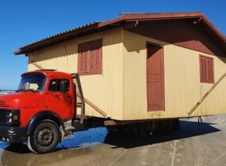 Caminhão transporta casas inteiras pela beira da praia no Litoral Norte